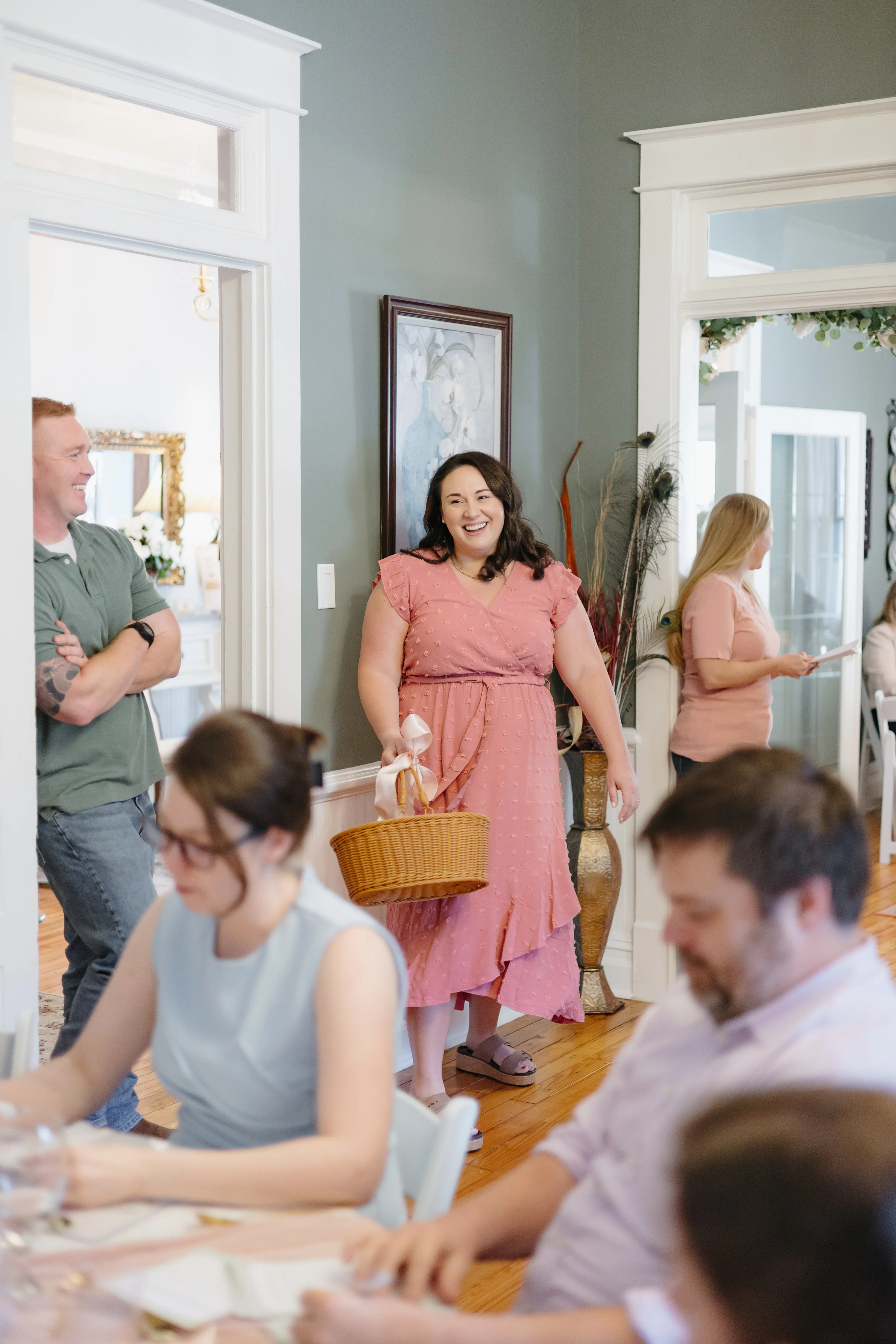 Woman arriving with a gift basket as guests gather for an event at The Magnolia Inn.