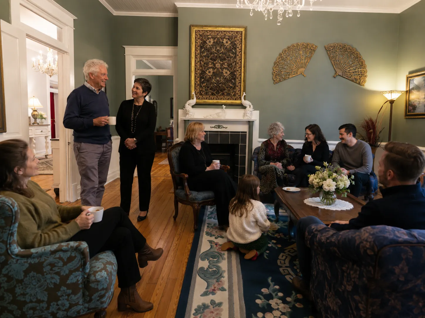 Multigenerational family reconnecting over coffee in a historic parlor.
