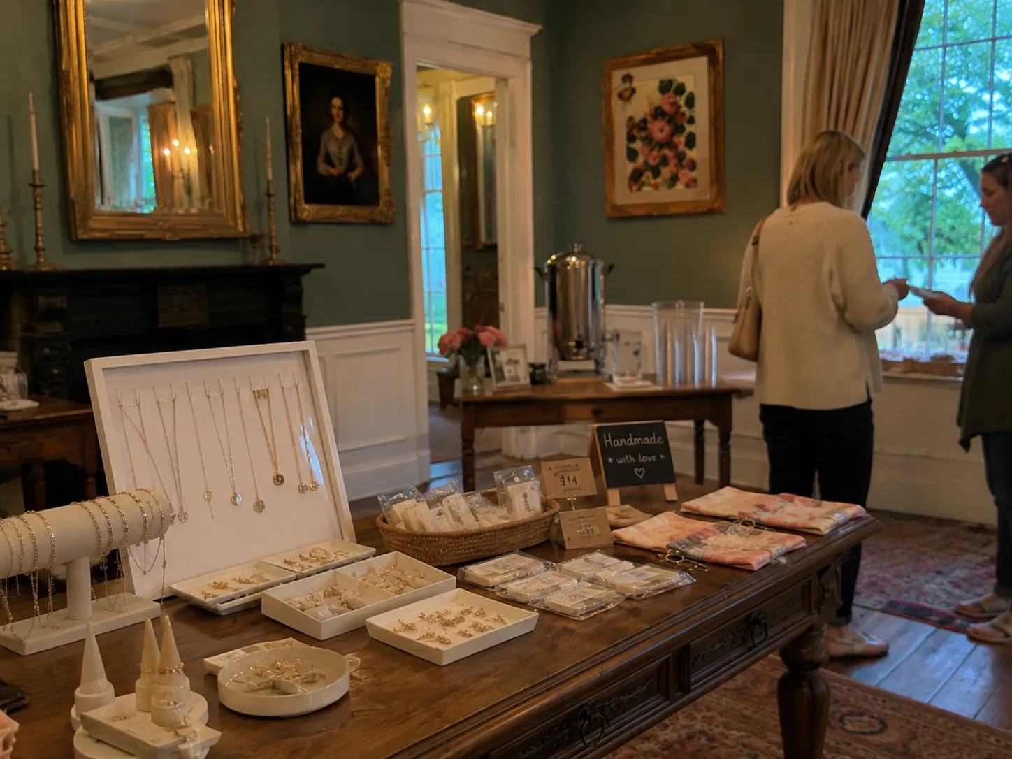 Five women sharing tea and conversation in a historic parlor.