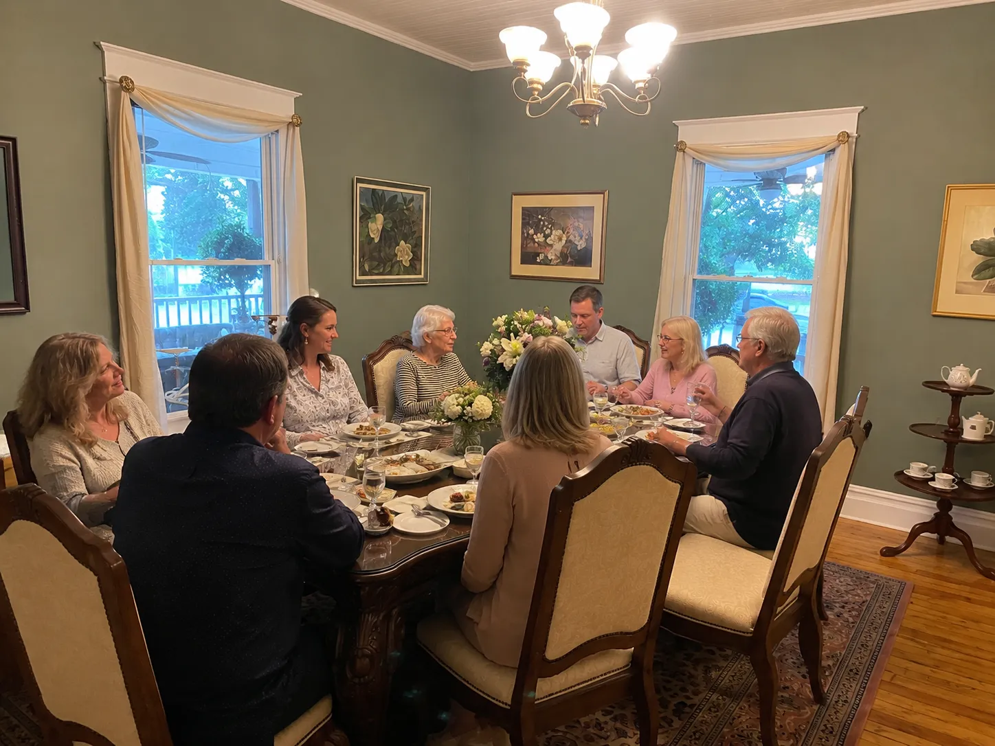 Family and friends sharing a meal during a celebration of life in a historic dining room.